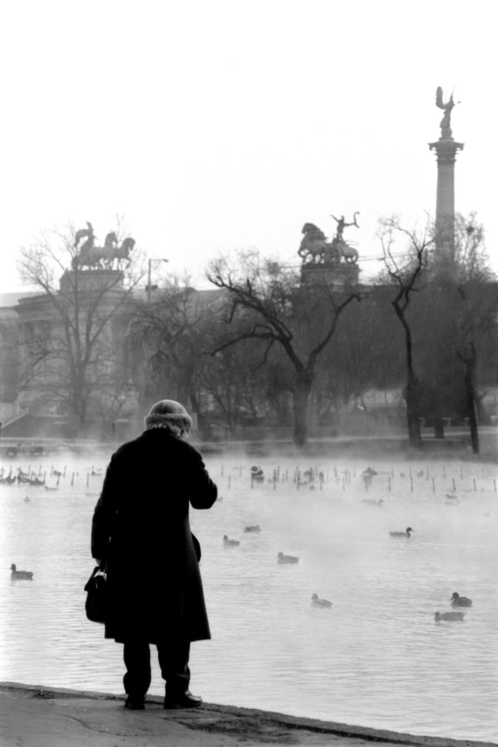 Old woman at Lake Heroes Square Budapest monochrome photograph by Francis Keating